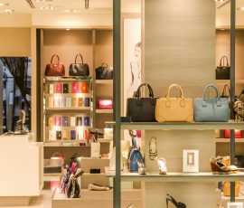 Europe Chic boutique with a variety of handbags and shoes elegantly displayed on shelves.