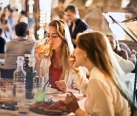 Europe Friends dining in a cozy Italian restaurant, enjoying drinks and food in a lively atmosphere.
